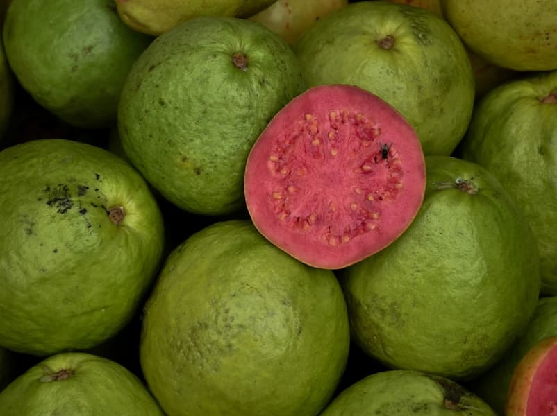 a pile of green and red fruit sitting on top of each other
